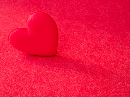 red heart on red paper texture backgroundの写真素材