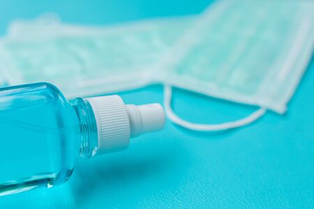 Surgical mask and spray alcohol for hand hygiene on green background.for the prevention of the flu and the Coronavirus, covid-19. Health care concept.Top viewの写真素材