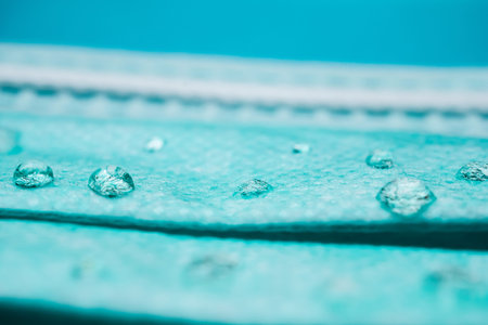 Drops of water on a surgical mask,prevention of the spread of virus flu and pandemic COVID-19