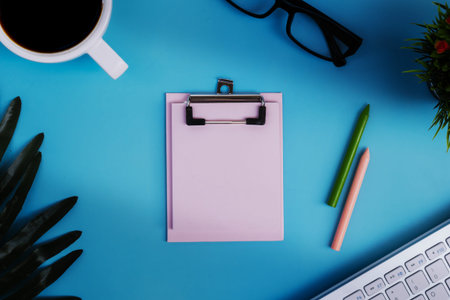 Top view workspace office business desktop blank Notepad with office accessories cup coffee on blue...