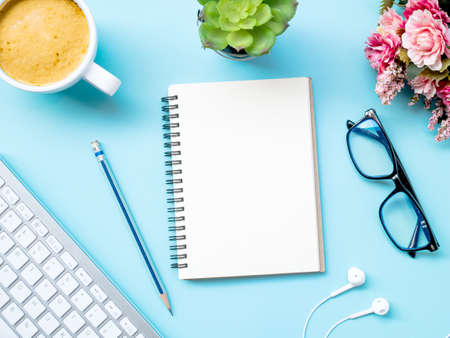 Top view workspace office business desktop with office accessories on blue backgroundの写真素材