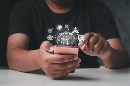 Hand holding smartphone with global network connection media icons and symbolの写真素材