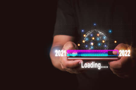 Businessman touching smartphone to virtual download bar Loading progress changing the new year 2021 to 2022,new ideas coming up in the futureの写真素材