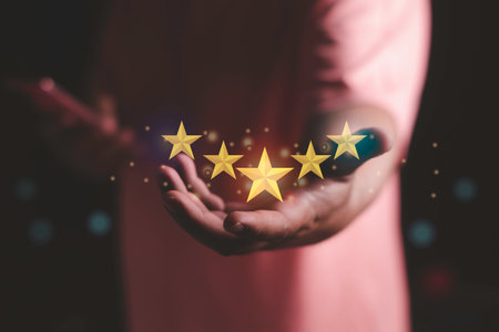 Customer or client satisfaction concept. hand holding the stars to five stars. giving a five star rating. happy service rating,positive feedback on Mobile Phoneの写真素材