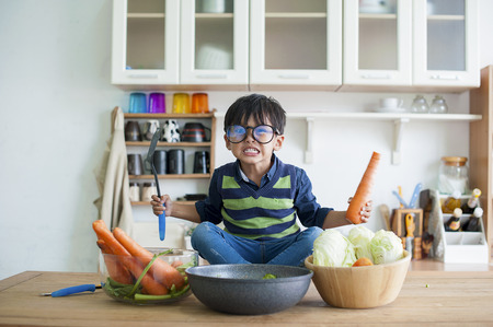 lovely boy cooking in kitchen.の写真素材