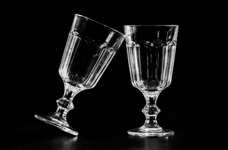 Close up of two glasses clinking together. Isolated on black background.の写真素材