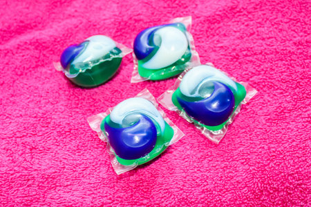 Laundry Day - laundry detergent pods on a laundry folding table with pink towels.