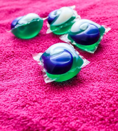 Laundry Day - laundry detergent pods on a laundry folding table with pink towels.の写真素材