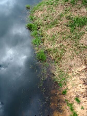 Abstract, clouds and blue sky mirrored on lake surfaceの写真素材