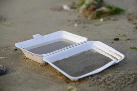 Thrown away takeaway carton sitting on the beach の写真素材