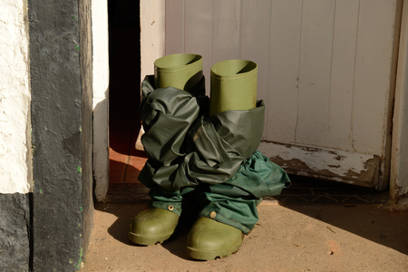Rubber boots with waterproof pants at door の写真素材