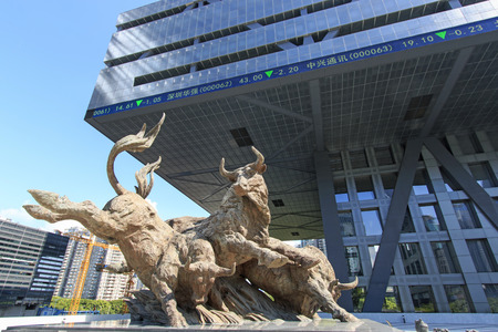Shenzhen, China - August 19,2015: Stock market building in Shenzhen, one of the three stock markets in China, with the copper bull statue on foreground. The others two Stock Markets of China are in Hong Kong and Shanghai. Shenzhen, China - August 19,2015: Stock market building in Shenzhen, one of the three stock markets in China, with the copper bull statue on foreground. The others two Stock Markets of China are in Hong Kong and Shanghai.