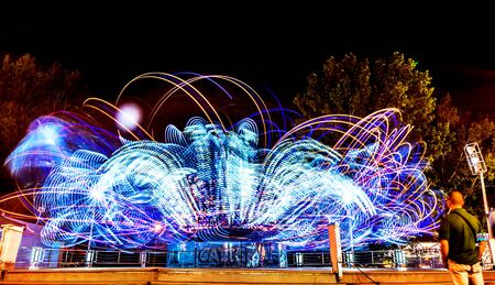 Night scene at luna park with rotating machine lights.の写真素材