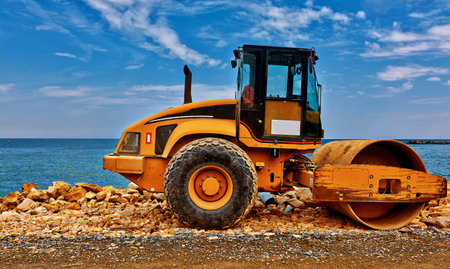 Yellow road building machinery ith seaside background.の写真素材