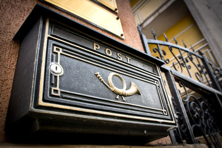 Black vintage mailbox with post written on it.の写真素材