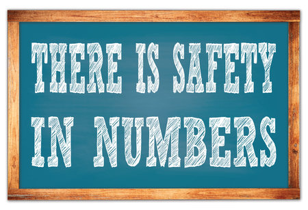 THERE IS SAFETY IN NUMBERS written on blue wooden frame school blackboardの写真素材