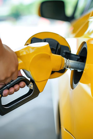 Photo a person pumping gasoline fuel in car at gas stationの素材
