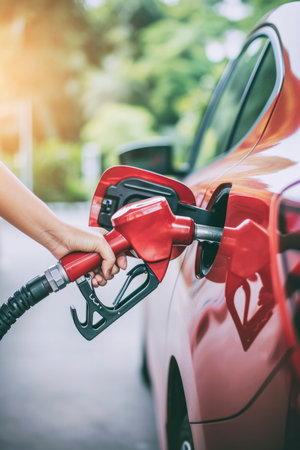 Photo a person pumping gasoline fuel in car at gas stationの素材
