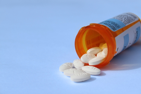prescription pills and bottle, isolated on blue backgroundの写真素材