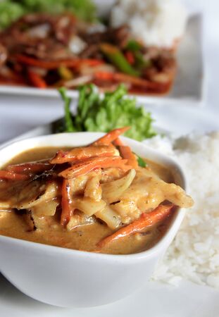 chicken in yellow curry served with white rice in a restaurantの写真素材