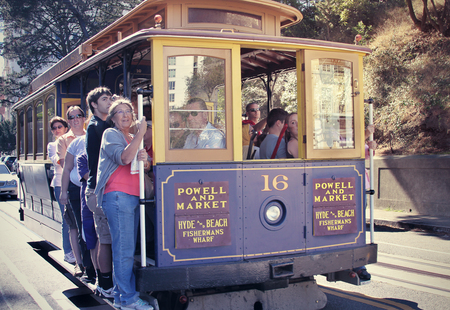 SAN FRANCISCO Ca. - Oct 5: Passengers ride in a cable car on Oct 5, 2014 in San Francisco. It is the most popular way to get around the City of San Fransisco.のeditorial素材