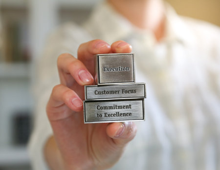 Woman holding metallic blocks with corporate values etched on them