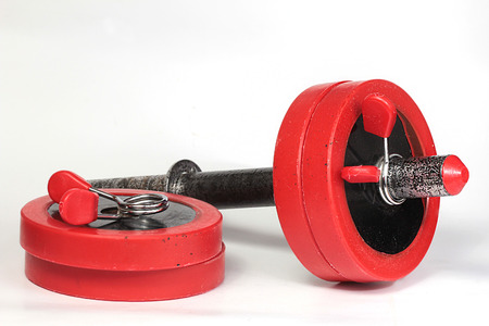 assembling red dumbbells on a homogeneous backgroundの写真素材