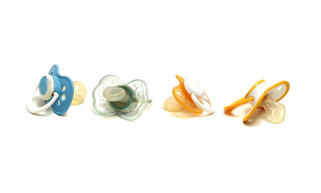 four dirty pacifiers on a white background