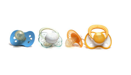 four dirty pacifiers on a white backgroundの写真素材