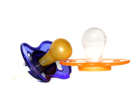 Two baby pacifiers on a white backgroundの写真素材