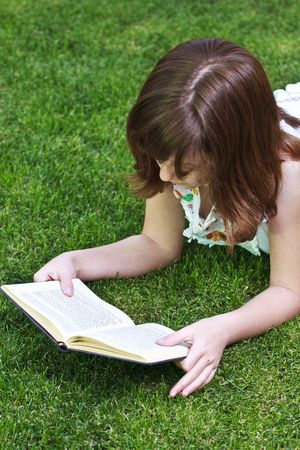 Young beautiful girl reading a book outdoorの写真素材