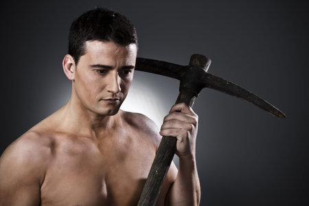 Farmer with pick axe  over black backgroundの写真素材