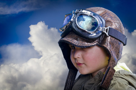 Child pilot, cute and funny over background cloudsの写真素材