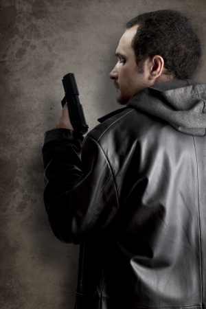 Man armed with gun on black textured backgroundの写真素材