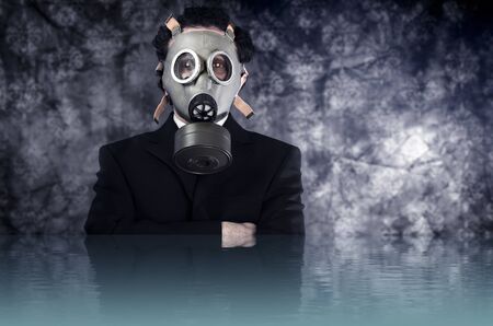 Risk concept, businessman with gas mask and black suit, water reflection effectの写真素材