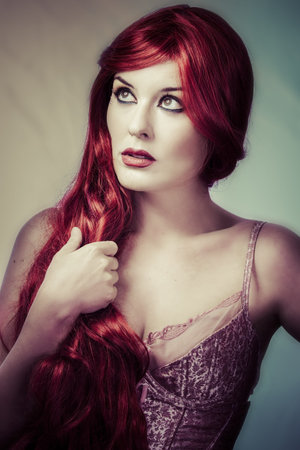 Sexy red haired woman with pink corset and lingerieの写真素材