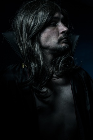 Vampire with black coat and long hair, blue lightの写真素材