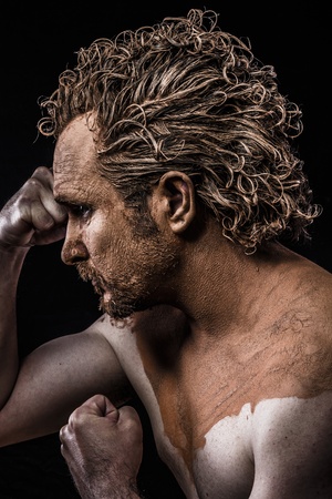 man covered in mud and nakedの写真素材