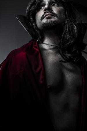 Sensual Young Vampire with black coat and long hairの写真素材