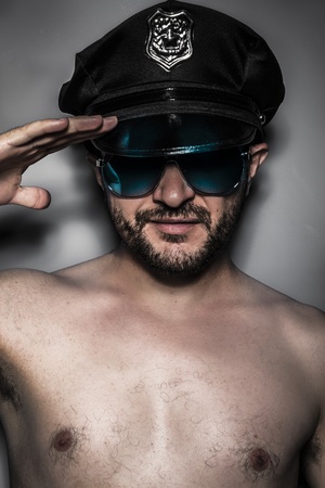 Sexy police,  man with cap and glasses, salutingの写真素材