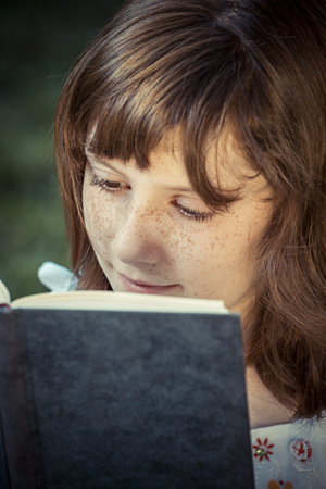 Student beautiful girl reading a book outdoor
