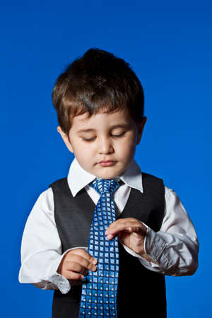Success, cute little boy portrait over blue chroma backgroundの写真素材