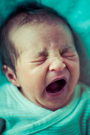 Newborn peacefully sleeping, picture of a baby curled up sleeping on a blanketの写真素材