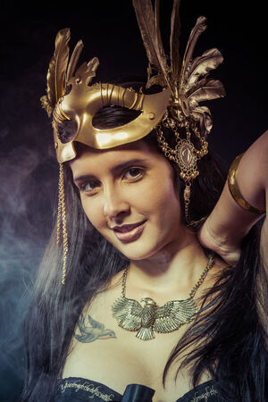Warrior woman with gold mask, long hair brunette. Long hair. Profile. Studio shotの写真素材