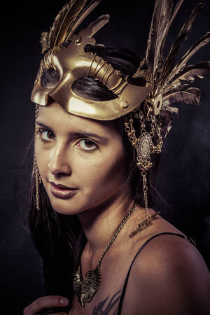Valkyrie, Golden statue concept. Arty portrait of model with golden mask and shiny lashes. Perfect sporty body. Long hair. Profile. Performanceの写真素材