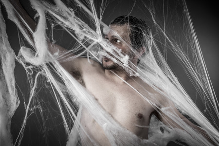 Scary network.man tangled in huge white spider webの写真素材
