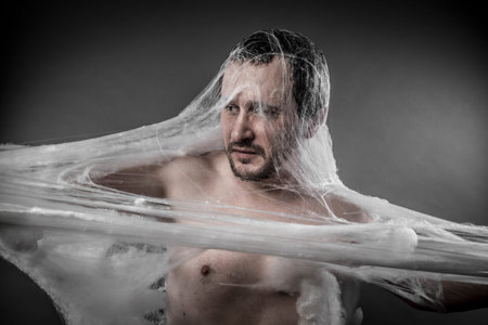 Trap.man tangled in huge white spider webの写真素材