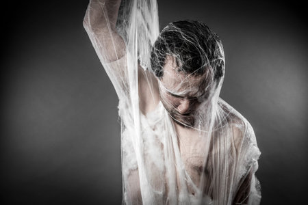 Trap.man tangled in huge white spider webの写真素材