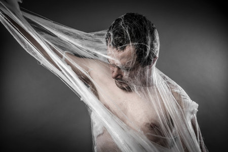 Scary network.man tangled in huge white spider webの写真素材