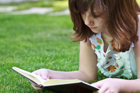 Study.Young beautiful girl reading a book outdoorの写真素材